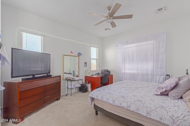 carpeted bedroom with ceiling fan and multiple windows