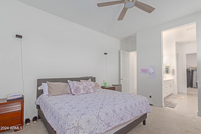 bedroom featuring ceiling fan, connected bathroom, and light colored carpet