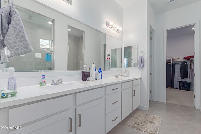 bathroom featuring a shower with door and vanity