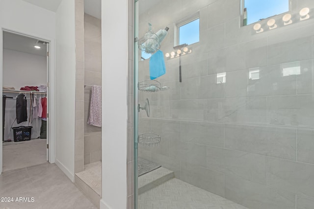 bathroom with tile patterned flooring and a tile shower