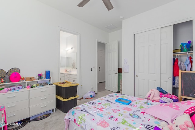 carpeted bedroom featuring ensuite bathroom, ceiling fan, and a closet