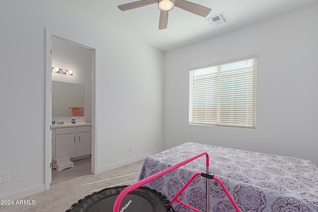 bedroom with ceiling fan, ensuite bath, and light carpet