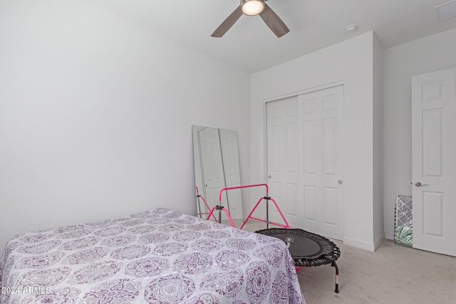 bedroom with light carpet, ceiling fan, and a closet