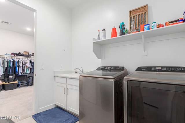 clothes washing area featuring light carpet, cabinets, sink, and washing machine and clothes dryer