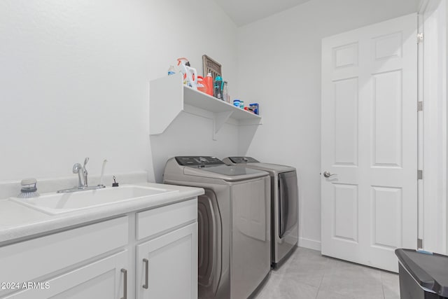 washroom featuring light tile patterned flooring, cabinets, washer and dryer, and sink