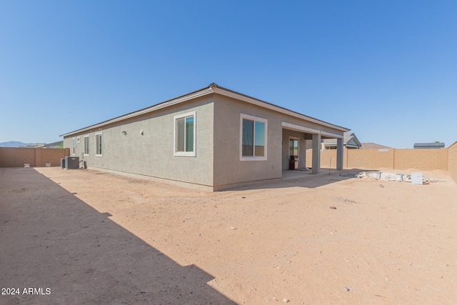 rear view of house featuring cooling unit and a patio area