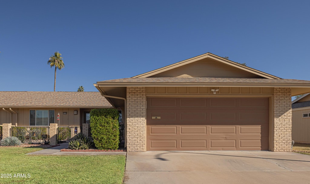 ranch-style home with a front lawn and a garage