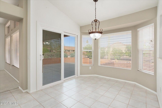 tiled spare room featuring plenty of natural light and vaulted ceiling