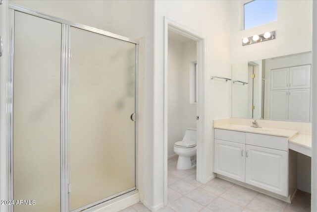 bathroom with oversized vanity, toilet, tile floors, and a shower with door