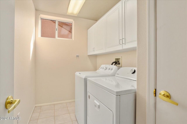 laundry area featuring washing machine and clothes dryer, cabinets, light tile floors, and hookup for a washing machine