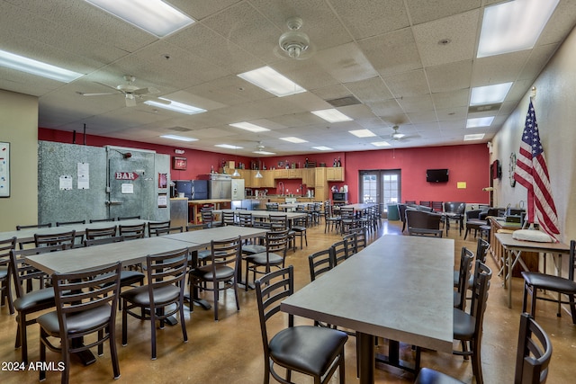 dining area featuring ceiling fan and a drop ceiling