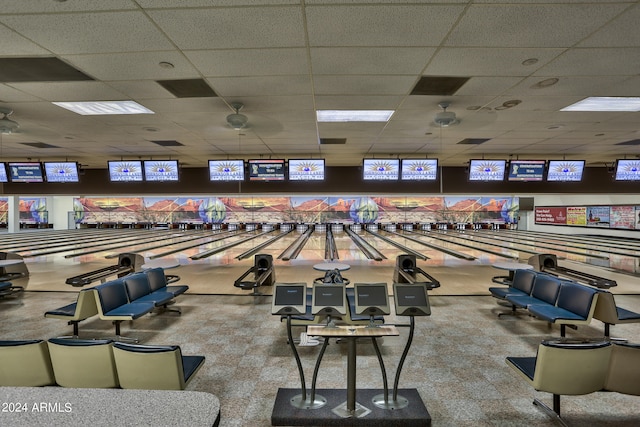 interior space with light colored carpet, ceiling fan, and a bowling alley