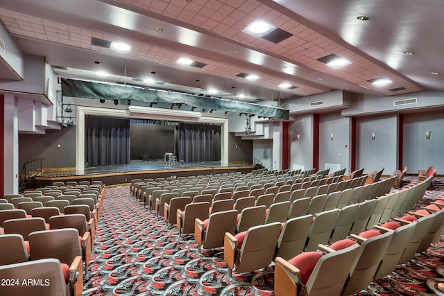 carpeted home theater room with a paneled ceiling