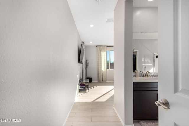 hall featuring light wood-type flooring and sink