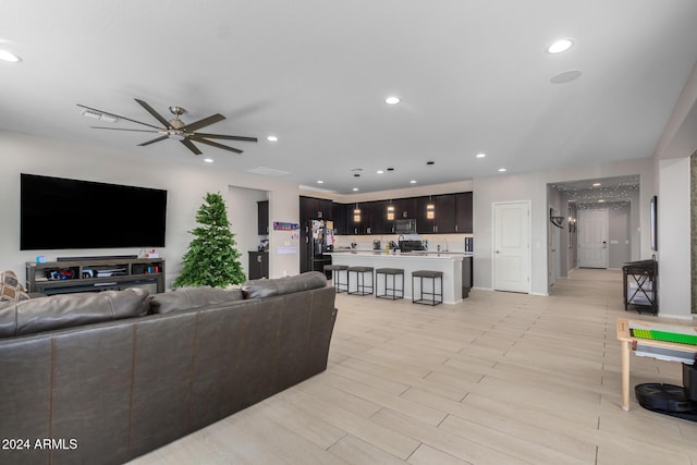 living room with ceiling fan and light hardwood / wood-style floors