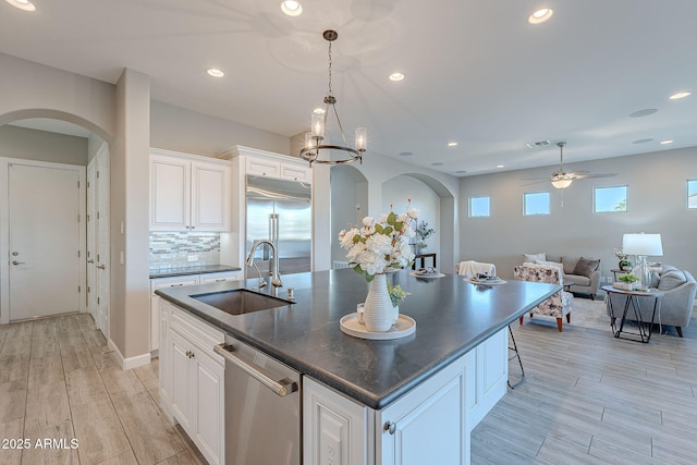 36169 N Serrano Ave, Queen Creek, AZ 85140 - kitchen featuring arched walkways, a sink, appliances with stainless steel finishes, dark countertops, and a ceiling fan