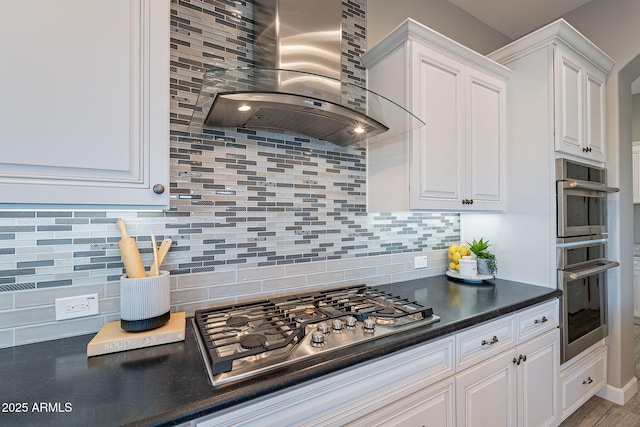 36169 N Serrano Ave, Queen Creek, AZ 85140 - kitchen featuring white cabinets, wall chimney range hood, dark countertops, stainless steel appliances, and decorative backsplash