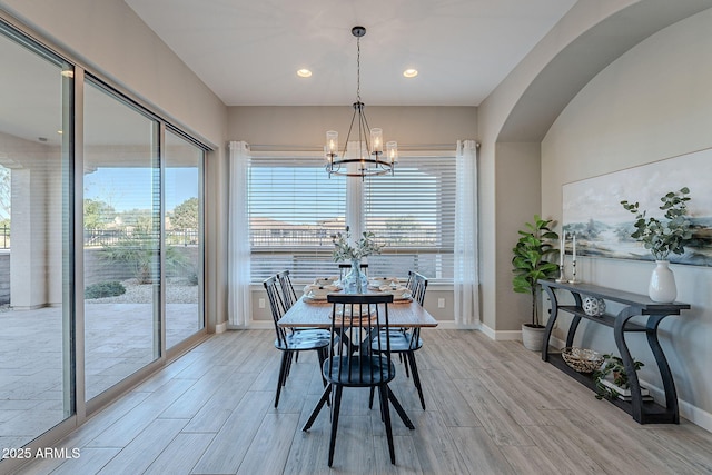 36169 N Serrano Ave, Queen Creek, AZ 85140 - dining area with a notable chandelier, baseboards, recessed lighting, arched walkways, and light wood finished floors