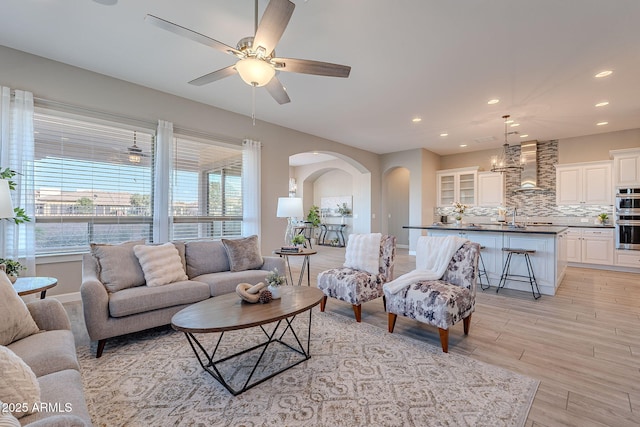 36169 N Serrano Ave, Queen Creek, AZ 85140 - living area featuring baseboards, arched walkways, ceiling fan, recessed lighting, and light wood-style flooring