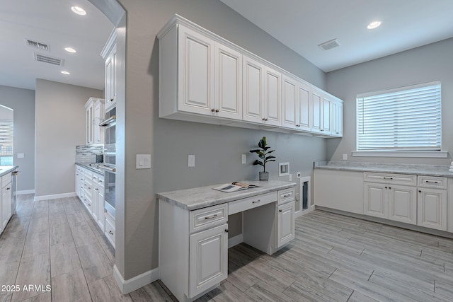 36169 N Serrano Ave, Queen Creek, AZ 85140 - kitchen with built in study area, visible vents, and light wood-style flooring