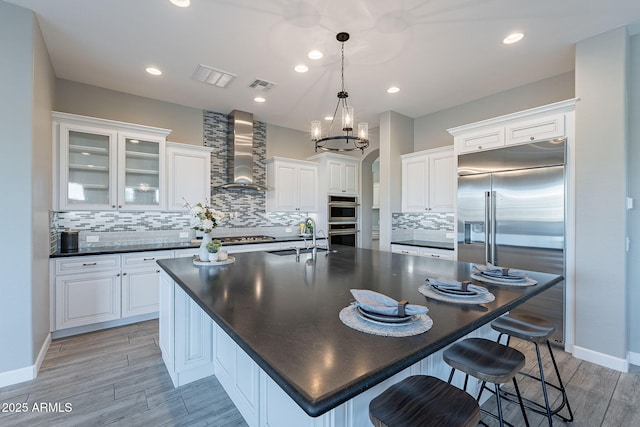 36169 N Serrano Ave, Queen Creek, AZ 85140 - kitchen featuring visible vents, a sink, wall chimney range hood, dark countertops, and stainless steel appliances