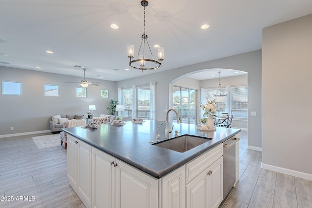 36169 N Serrano Ave, Queen Creek, AZ 85140 - kitchen with baseboards, open floor plan, arched walkways, dishwasher, and a sink