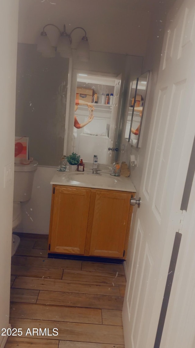 bathroom with wood-type flooring, toilet, and vanity