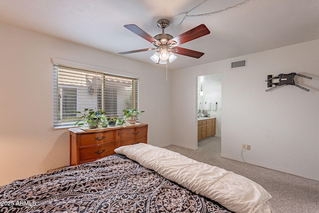 bedroom with ensuite bath, light colored carpet, and ceiling fan