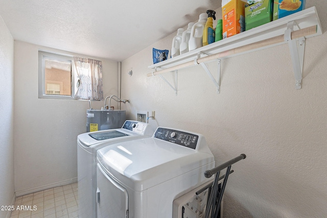 washroom featuring water heater, washing machine and dryer, and a textured ceiling