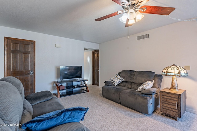 carpeted living room featuring ceiling fan and a textured ceiling