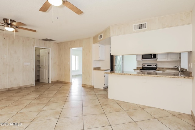 kitchen featuring stainless steel appliances, visible vents, a peninsula, and white cabinetry