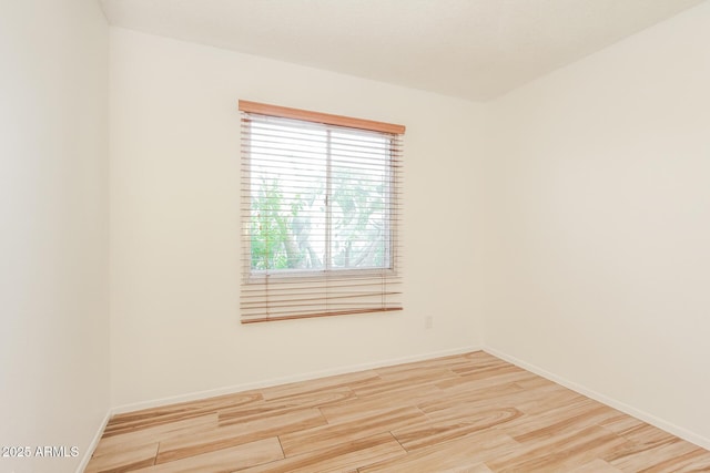 unfurnished room with baseboards and wood finished floors