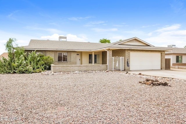 single story home featuring concrete driveway, brick siding, an attached garage, and a shingled roof