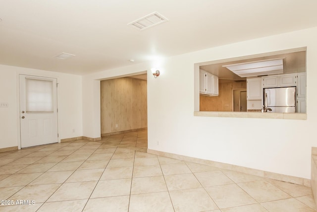 spare room featuring visible vents, baseboards, and light tile patterned floors