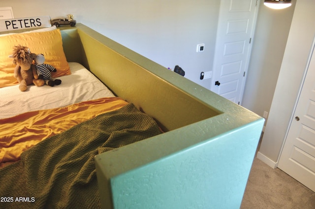 bedroom with light colored carpet and baseboards