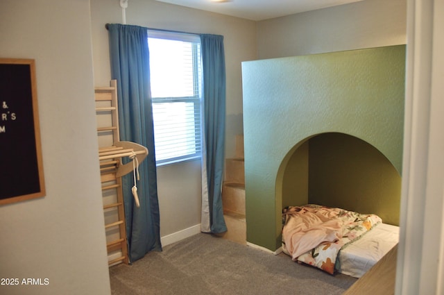 bedroom featuring baseboards, multiple windows, and carpet