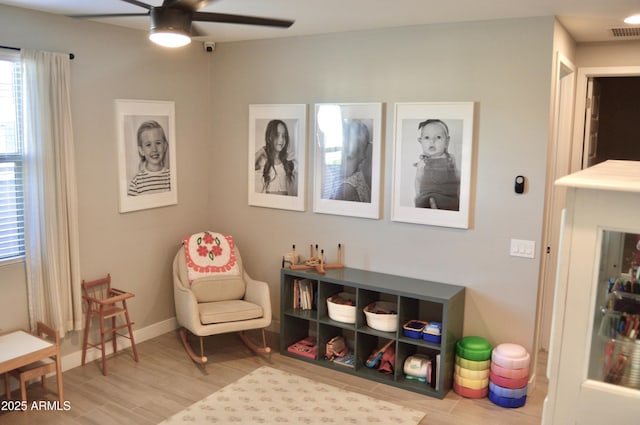 sitting room with visible vents, baseboards, and ceiling fan