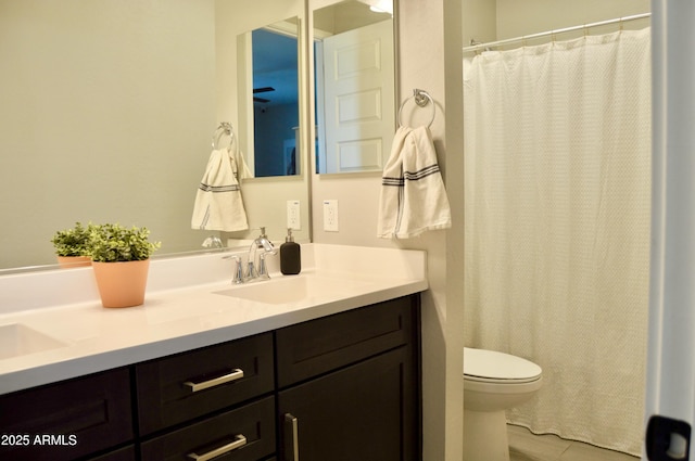 full bathroom with double vanity, toilet, and a sink