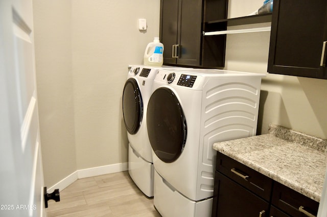 laundry room with baseboards, cabinet space, and washing machine and clothes dryer