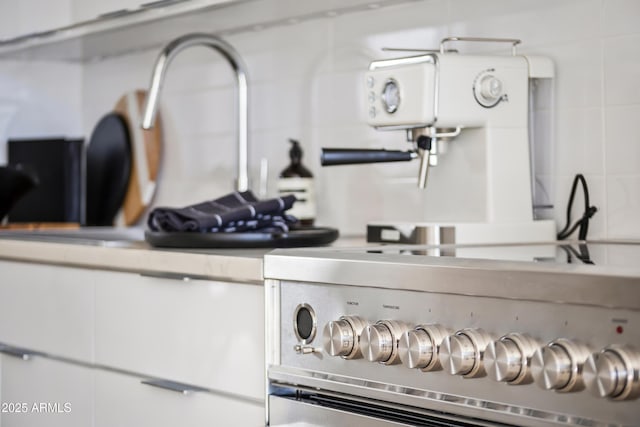 interior details featuring light countertops, white cabinetry, and high end stainless steel range