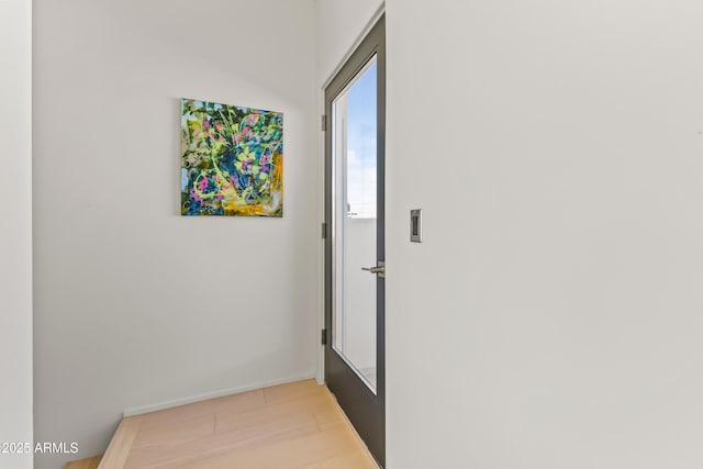 hallway with light hardwood / wood-style floors