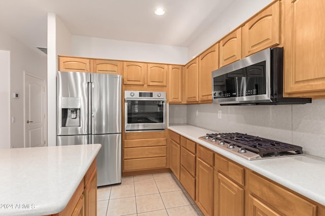 kitchen with decorative backsplash, appliances with stainless steel finishes, light tile patterned flooring, and light brown cabinets