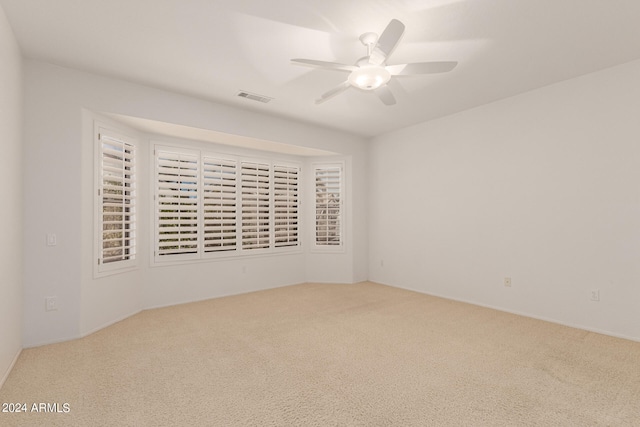 carpeted empty room featuring ceiling fan