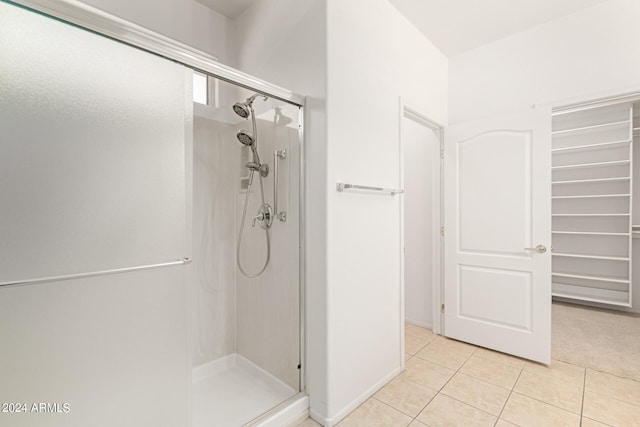 bathroom with an enclosed shower and tile patterned floors