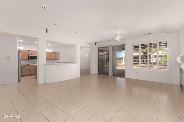 interior space with ceiling fan and light tile patterned floors