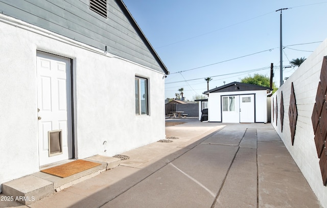 view of home's exterior featuring an outbuilding and a patio