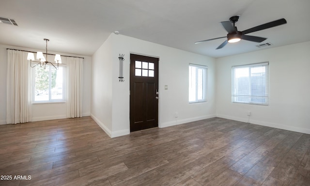 entrance foyer featuring ceiling fan with notable chandelier, a wealth of natural light, and dark hardwood / wood-style floors