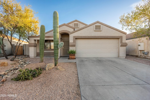 view of front of home with concrete driveway, fence, an attached garage, and stucco siding