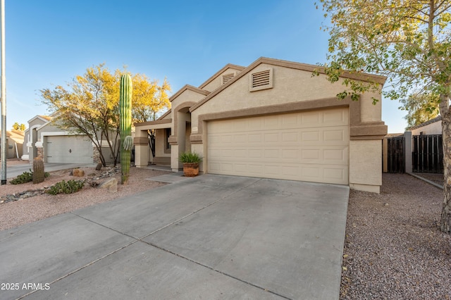 view of front of property with driveway, an attached garage, fence, and stucco siding