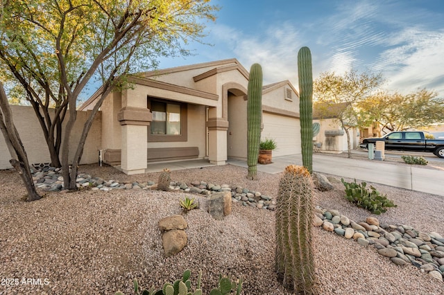 view of front of property with driveway, a garage, and stucco siding